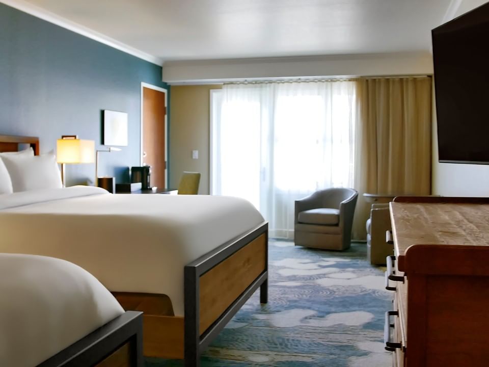 Double Queen room with two queen rooms, an armchair and a TV at The Stanley Hotel