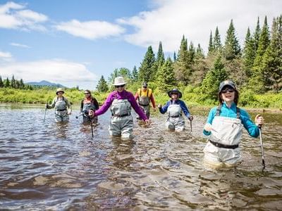 Group of hikers in a river at Adirondack near High Peaks Resort