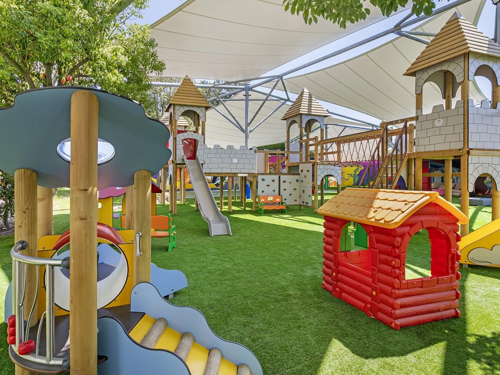 An outdoor kids play area with slides and playhouses in Tini Kids Club at Titanic Deluxe Golf Belek