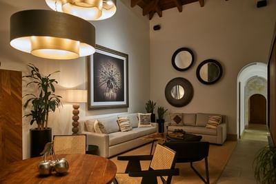 Living and dining area with modern sofas, mirrors, and large pendant lights at Singular Signature Residences