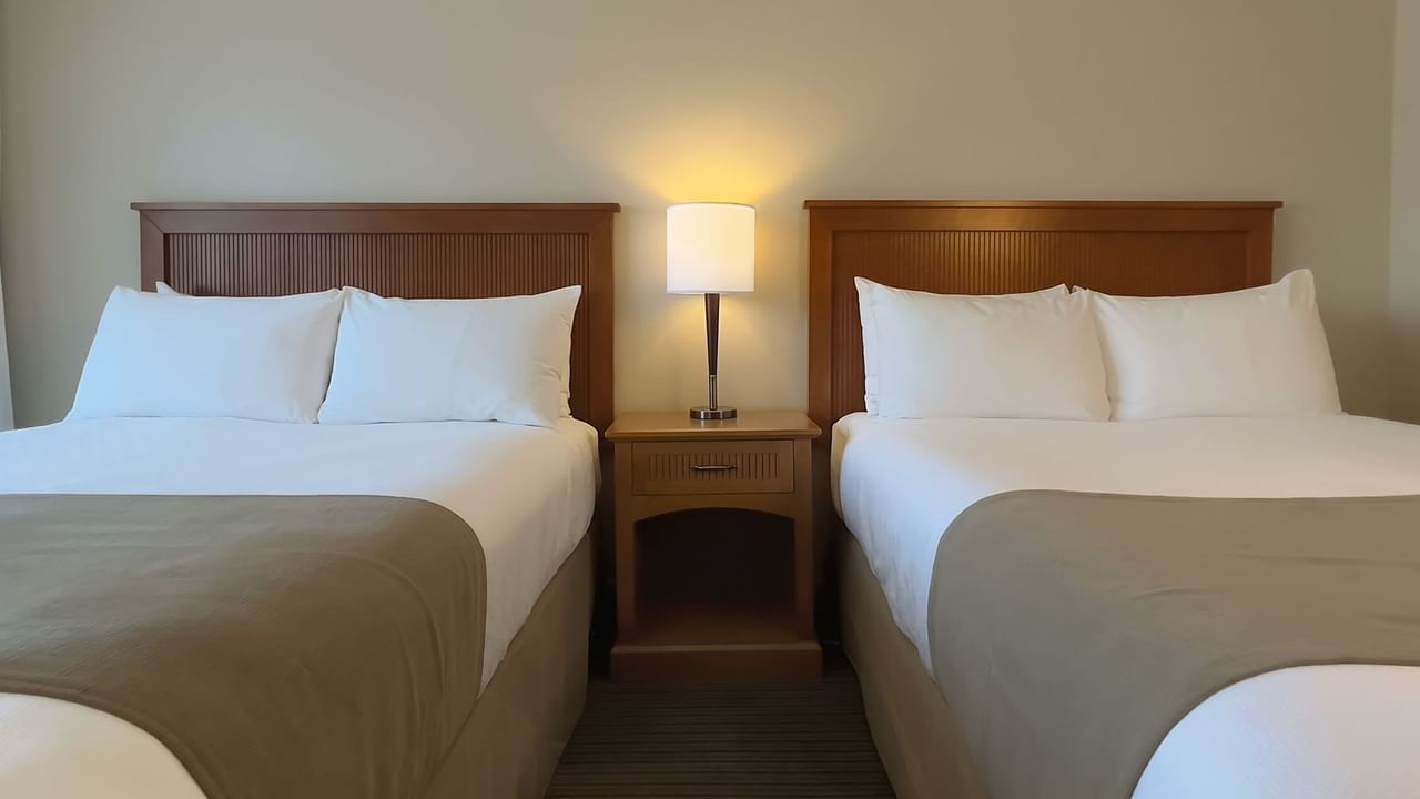 Guest room with two double beds and lamp