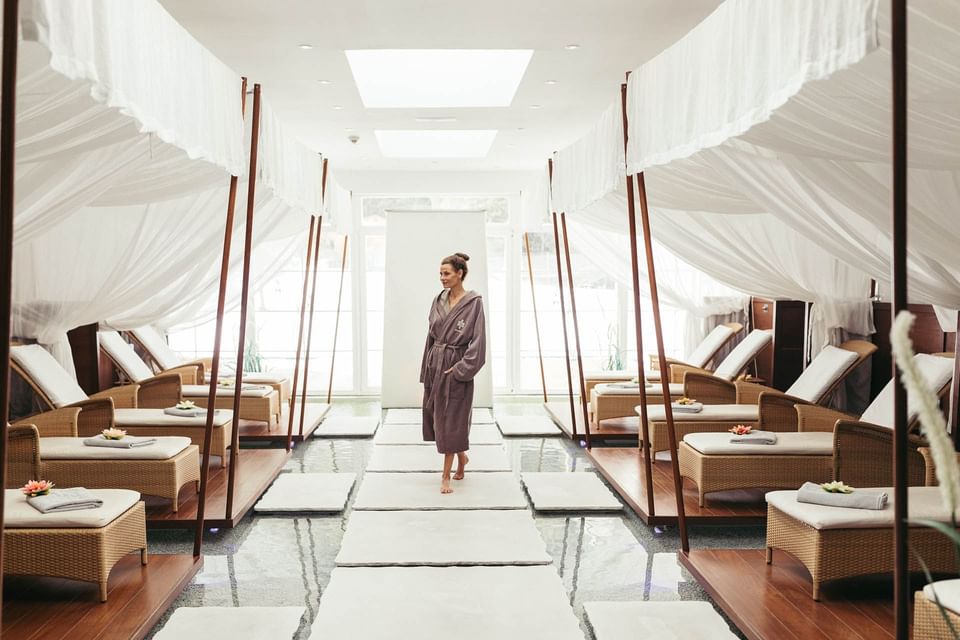 A lady standing by loungers in Orjola Spa at Liebes Rot Flueh