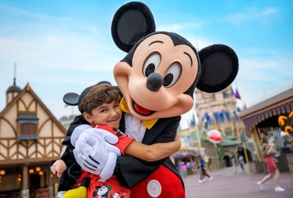  Boy in Mickey ears hugging Mickey Mouse at Walt Disney World, which has multiple character dining options.