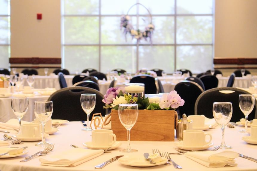 Elegant table setting with purple flowers by wine glasses in Brudenell at Rodd Brudenell River Resort