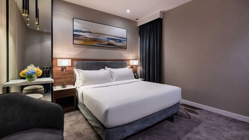 Bed with nightstand and couch in Standard Room at Warwick Hotels & Resorts
