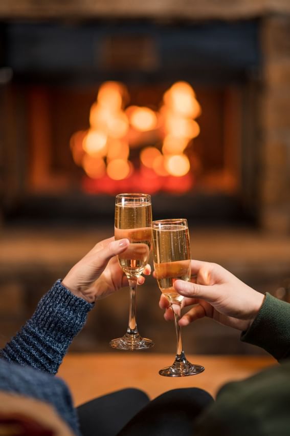 Close-up of a couple clinking champagne glasses, The Lake House