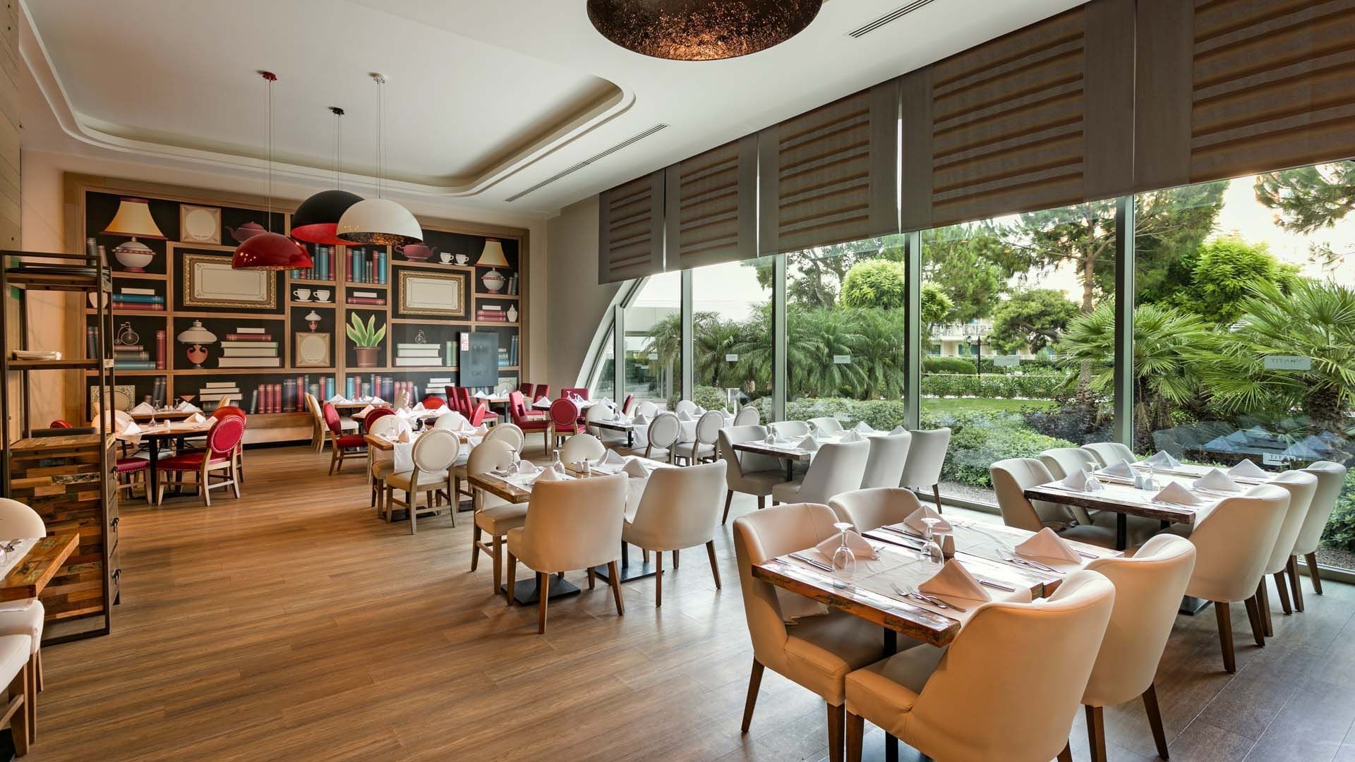 Dining area with plush seating and tables in Parkfora Main Restaurant at Titanic Deluxe Lara