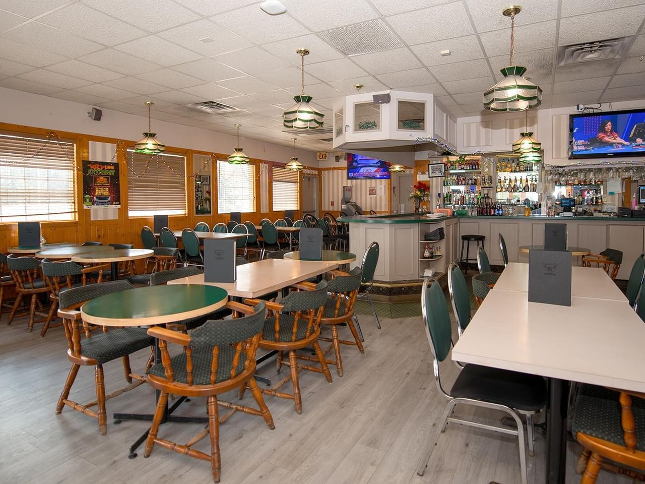 dining area with tables, chairs and televisions at Green Gables Restaurant & Lounge
