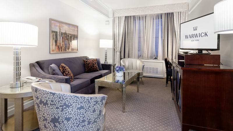 Living area with working table and couch in Premier Suite at Warwick New York