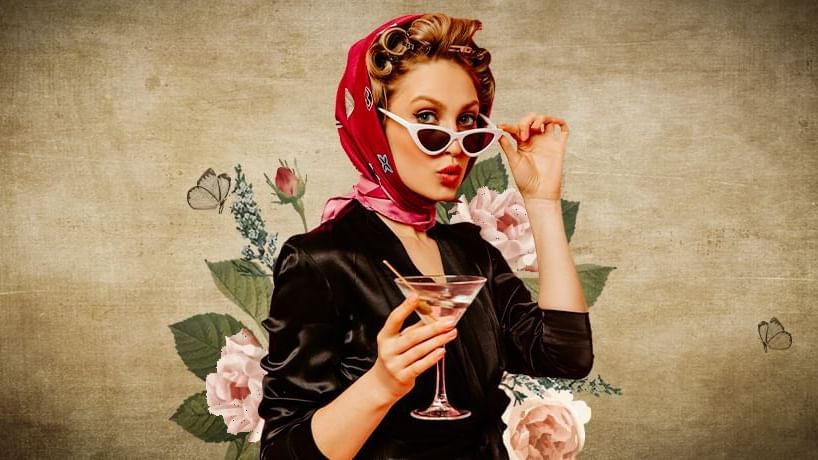 Stylish figure holding a martini, surrounded by floral decorations against a textured backdrop at Paramount Hotel Dubai