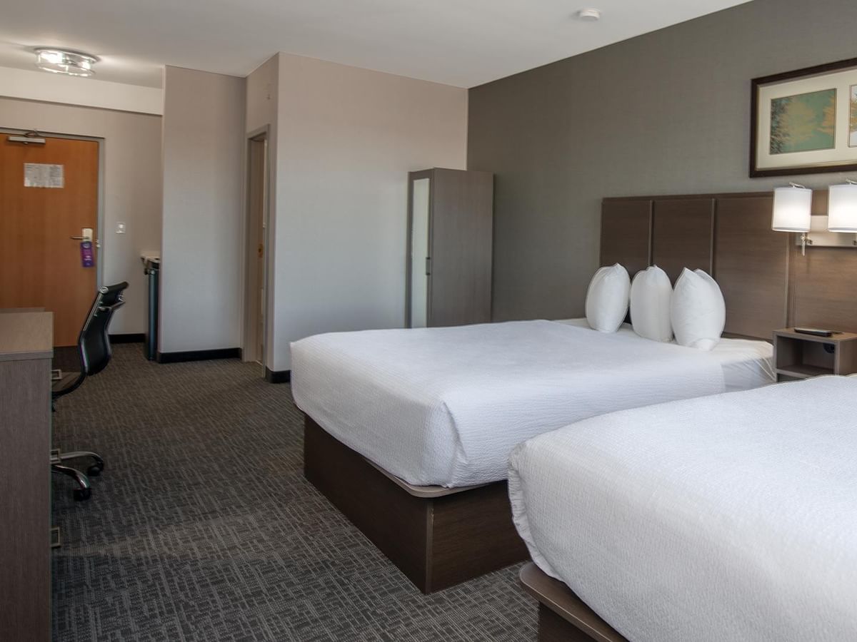 Room with two queen beds, desk, and chair.