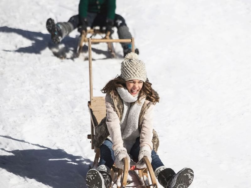A kid enjoying a sleigh ride near Falkensteiner Hotels