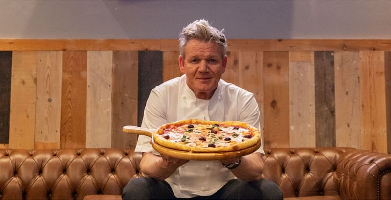 Gordon Ramsay proudly presents a freshly baked pizza, topped with olives and basil, at Sunway resort