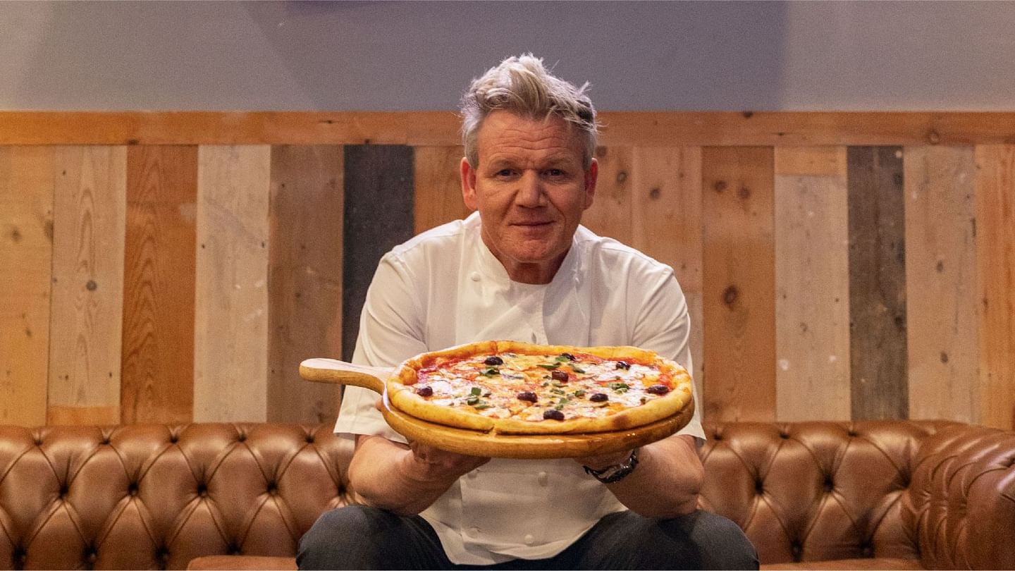 Gordon Ramsay in chef's whites, proudly presenting a freshly baked pizza at Sunway Lagoon Hotel's Street Pizza restaurant