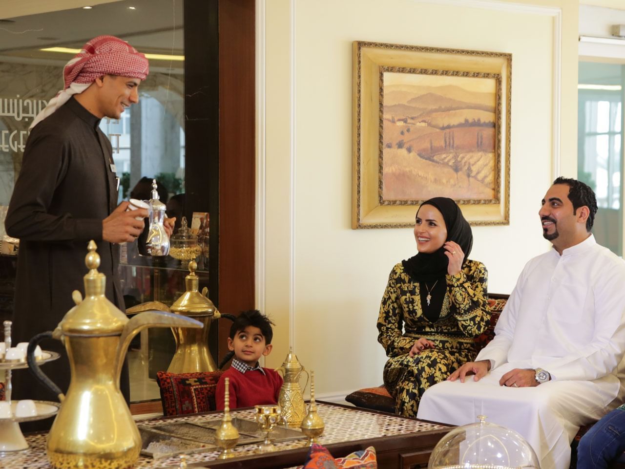 A waiter serving drinks to a family at The Regency Hotel