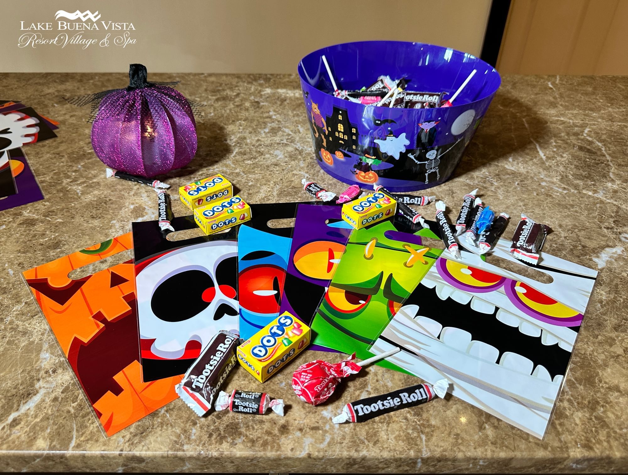 Child receiving treats in a pumpkin bucket at Lake Buena Vista Resort Village & Spa