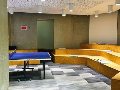A modern room with a ping pong table and seating area at UniLodge Auckland City.
