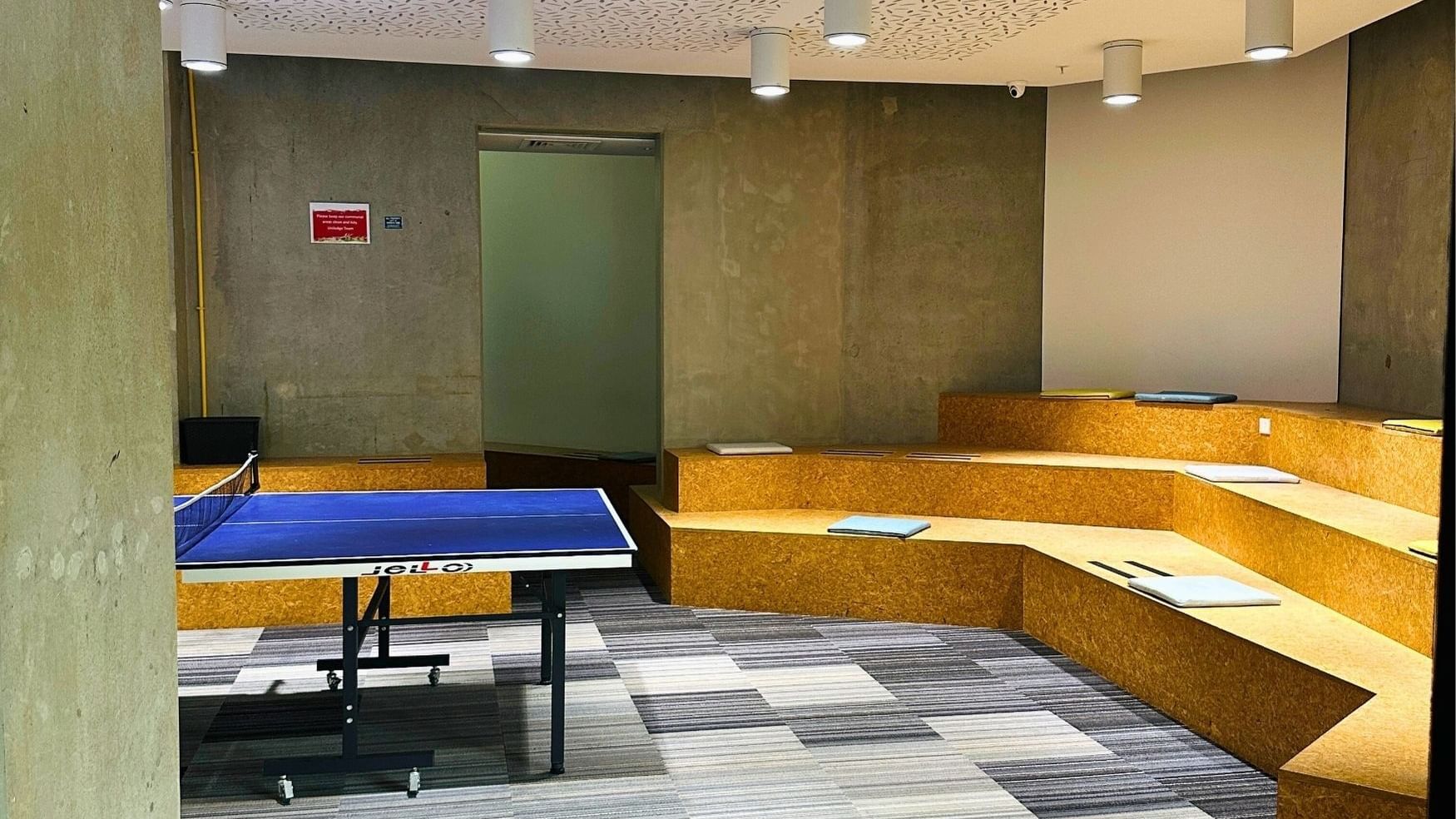 A modern room with a ping pong table and seating area at UniLodge Auckland City.