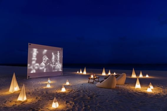 A beach setting for a romantic dinner at night, with a table near Grand Park Kodhipparu, Maldives