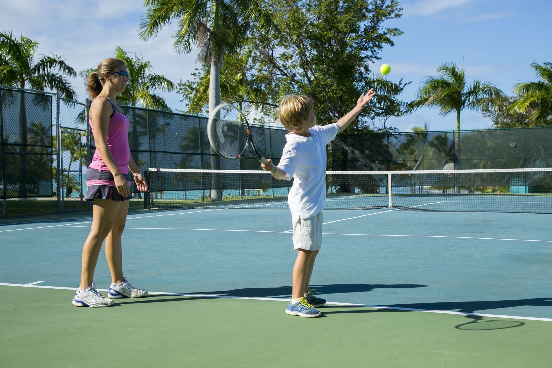 A mom & son playing at a tennis court in Buccaneer Hotel