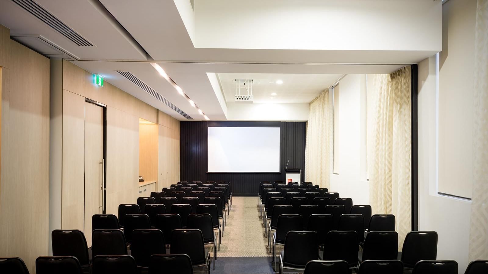 Theater-style set up facing a large screen in The Think Tank at Ibis Adelaide