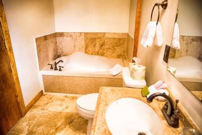 Lodge bathroom with stone backsplash.