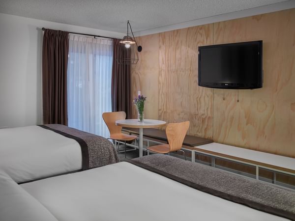 Two beds facing TV in hotel room
