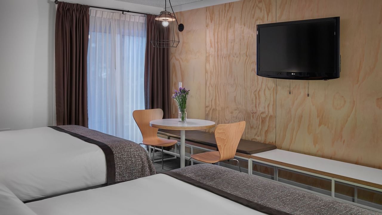 Two beds facing TV in hotel room