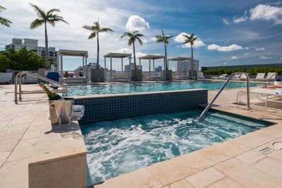 rooftop pool and jacuzzi with cabanas and lounge chairs