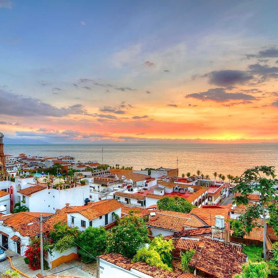 Puesta de sol sobre Puerto Vallarta con vista de la ciudad y el mar.