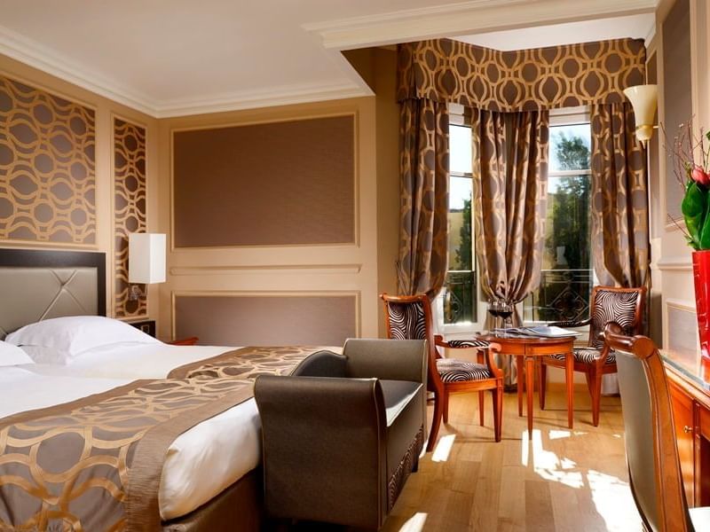 King bed, comfy sofa, coffee table & chairs in Deluxe Twin Room at Grand Visconti Palace