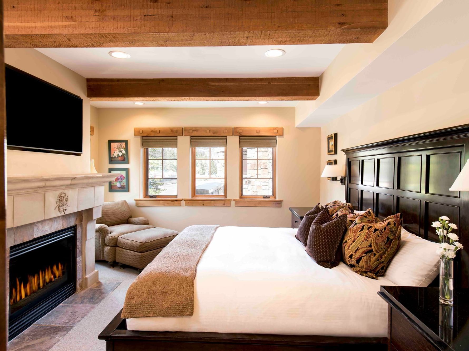 Bed and seating by fireplace in One King Room at Chateaux Deer Valley