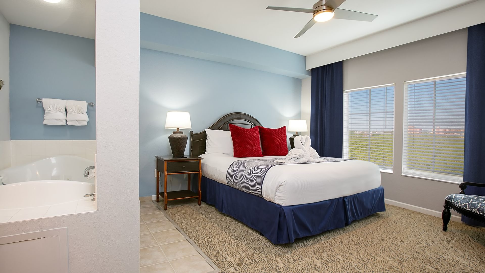 A hotel room with a bed, nightstand, chair, and window