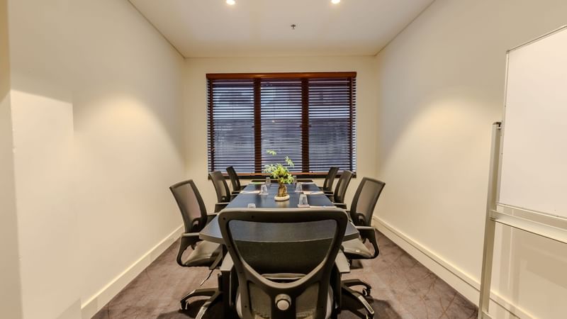 ibis Board room with note pad pen, natural light, white board and plants