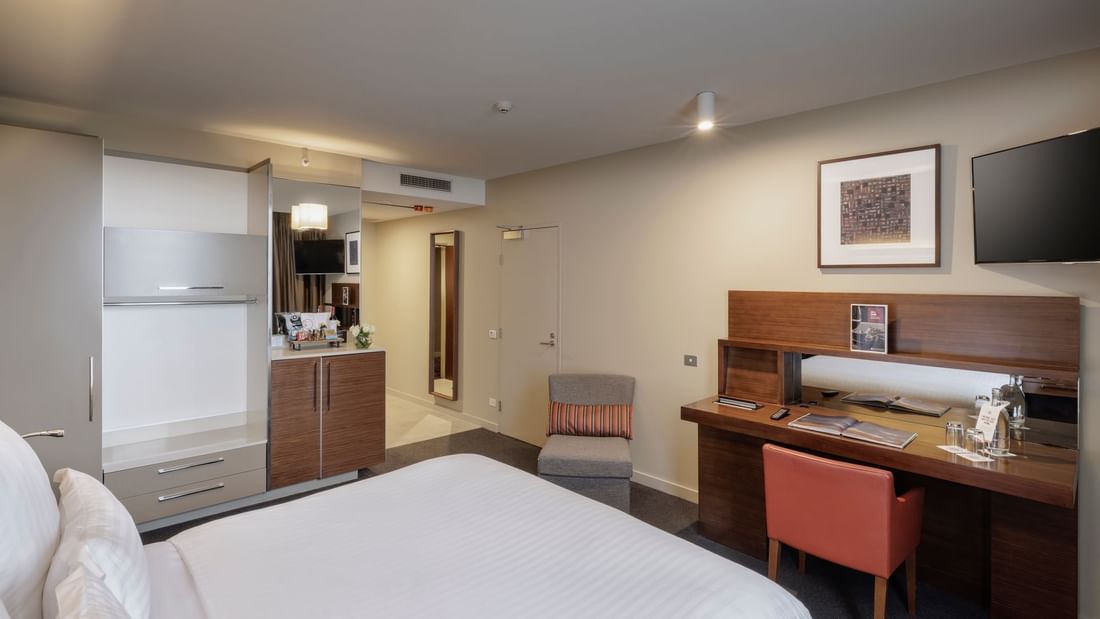 TV with work desk facing bed by the closet in Pullman Superior King Accessible Room 351 at Pullman Sydney Olympic Park