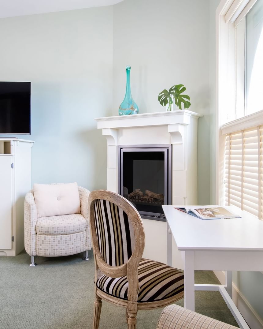 Work desk next to fireplace, TV & comfy chair in Premiere Loft Nantucket at Retro Suites Hotel