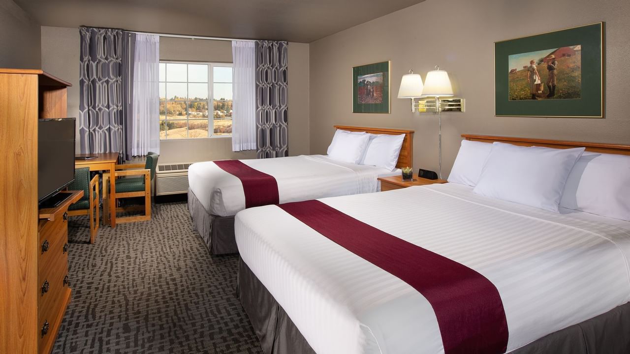 Two beds in stylish hotel room with window