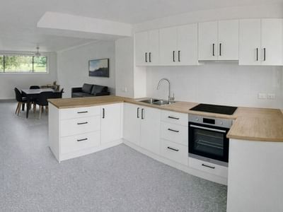 White kitchen and dining area with furniture and appliances at UniLodge SCU Lismore - Sirius.