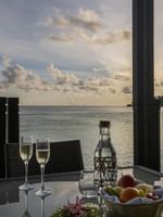 Waterfront dining table set with champagne glasses and fruit basket in Overwater Villa Terrace at warwick le lagon-vanuatu