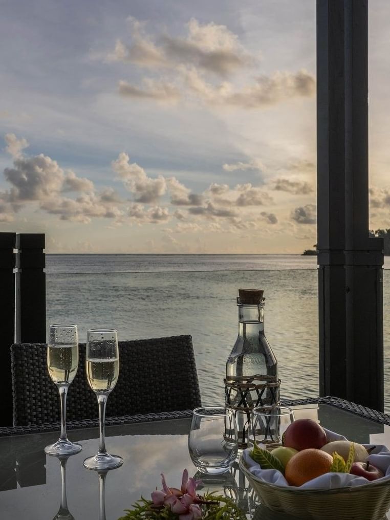 Waterfront dining table set with champagne glasses and fruit basket in Overwater Villa Terrace at warwick le lagon-vanuatu