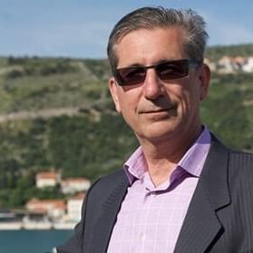 A man wearing a suit and sunglasses posing for a photo