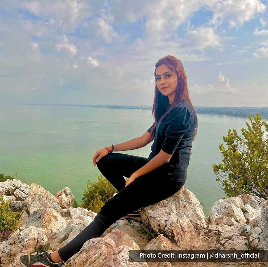 a girl sitting on a rock with a beautiful view behind her - Lexis PD