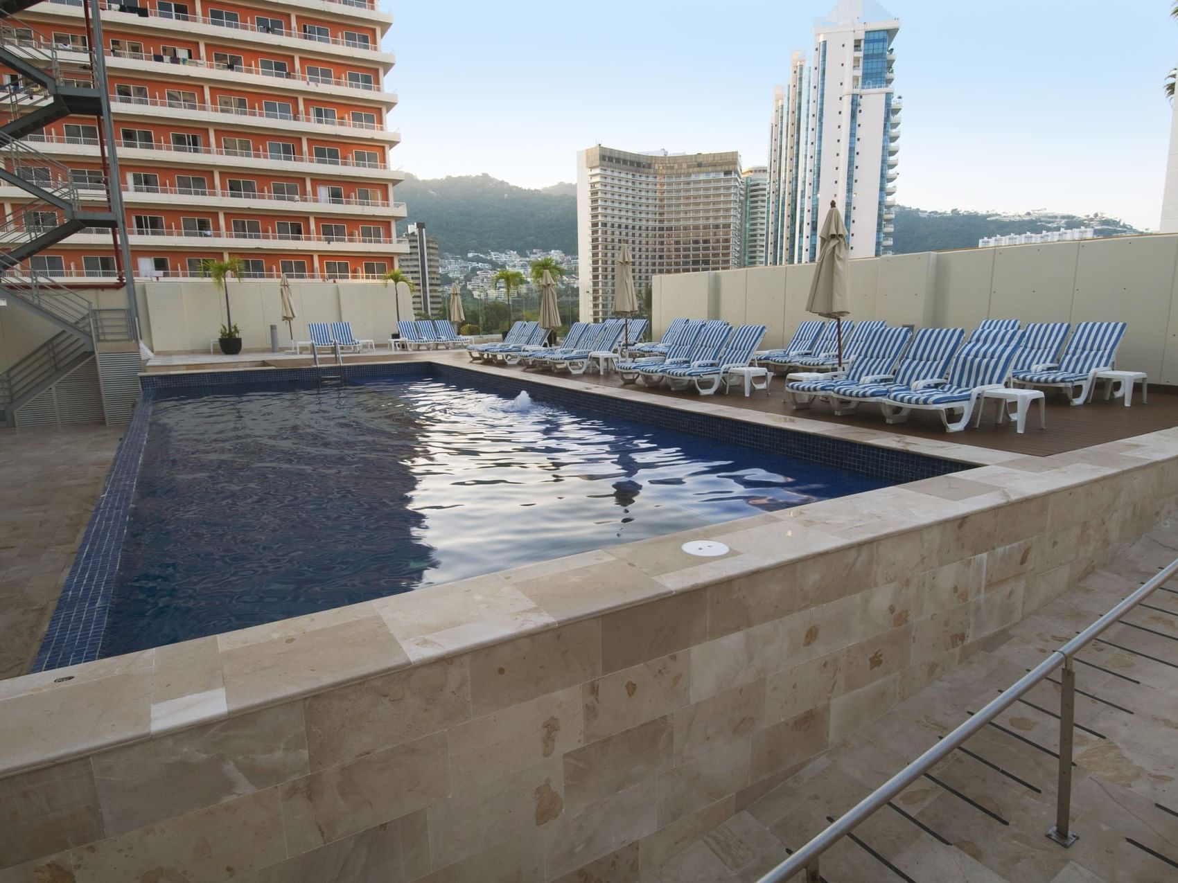Outdoor pool with pool loungers at One Hotels