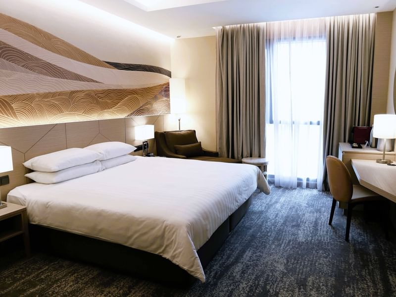 King-size bed and TV in A Basic One King at Sunway Putra Hotel