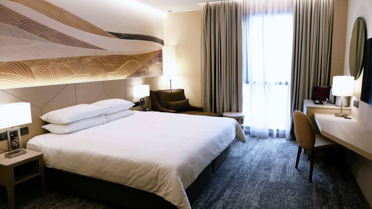 King-size bed and TV in A Basic One King at Sunway Putra Hotel