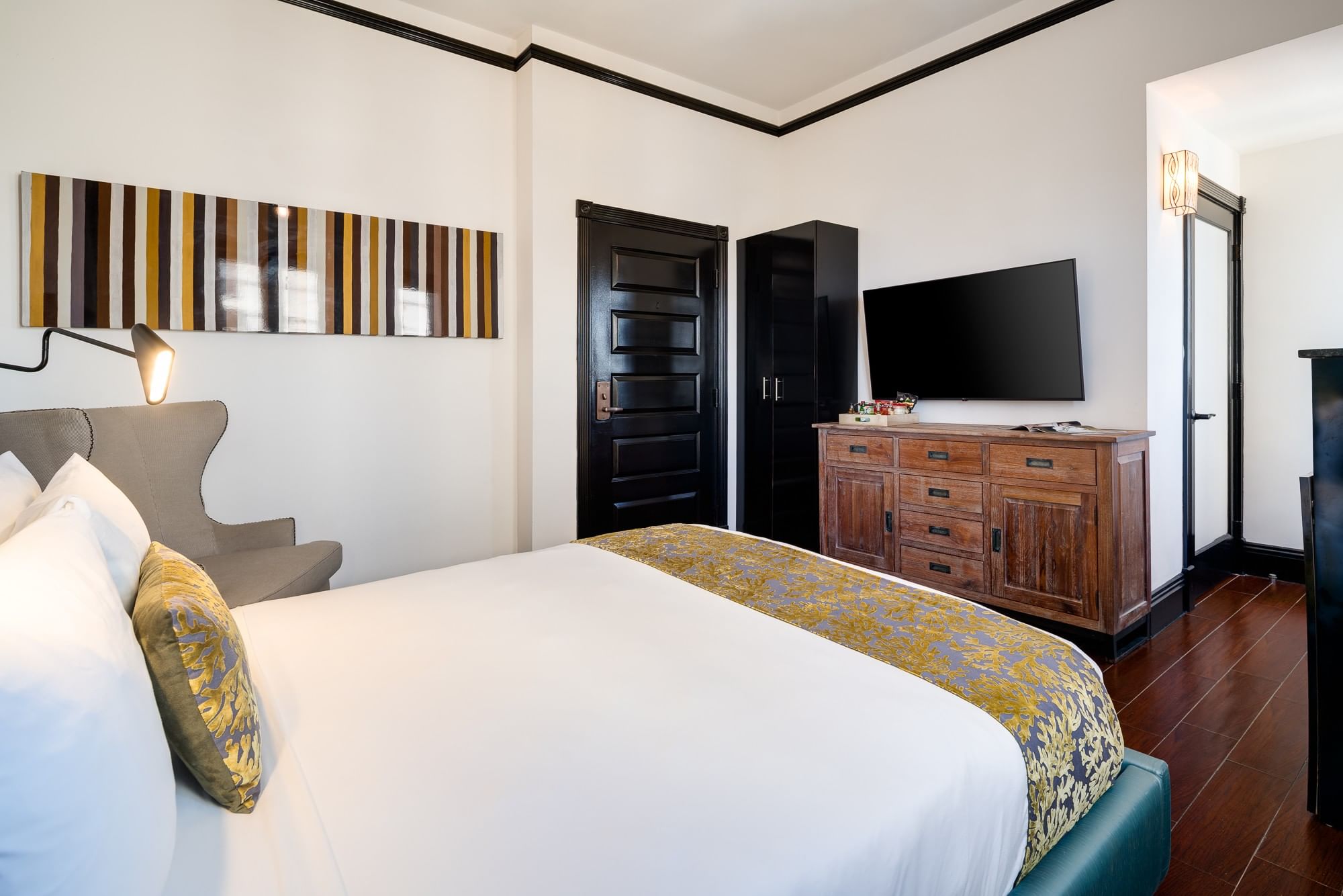 A hotel room with a bed, dresser, chair, and TV