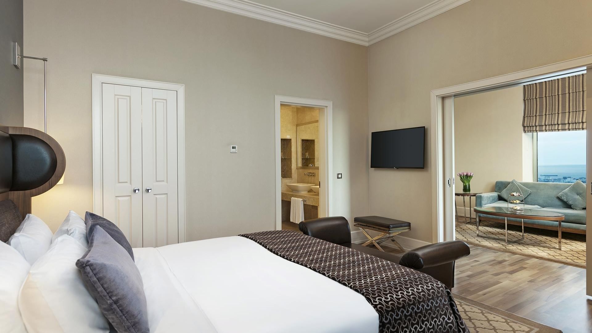 Titanic Business Kartal'daki Premier Suite'te, yatak ucu bankosu bulunan çift kişilik yatak ve duvara monte edilmiş bir televizyon yer almaktadır.