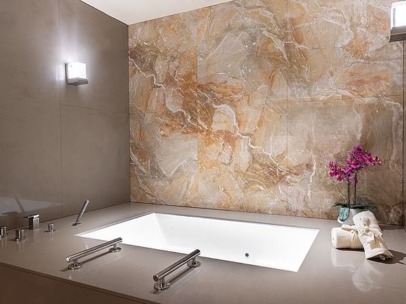 large bathtub with marble wall