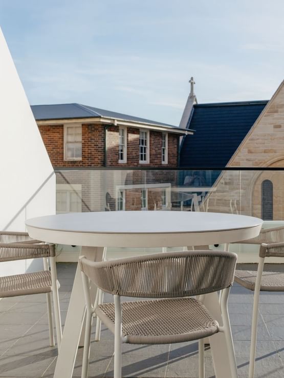 Village Terrace Twin at Elysium Manly with a round table by woven chairs under a glass railing, best places to stay in Manly