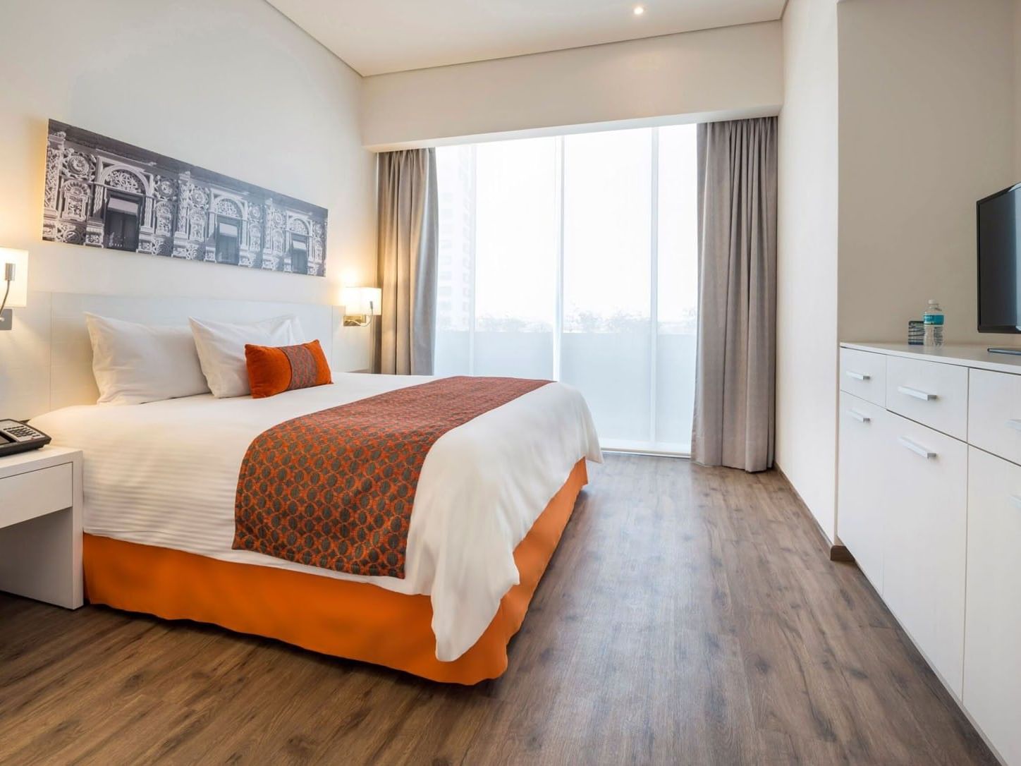 King Suite 2 Rooms with a large window, wooden floors, and a plush king bed at Camino Real Puebla Angelopolis